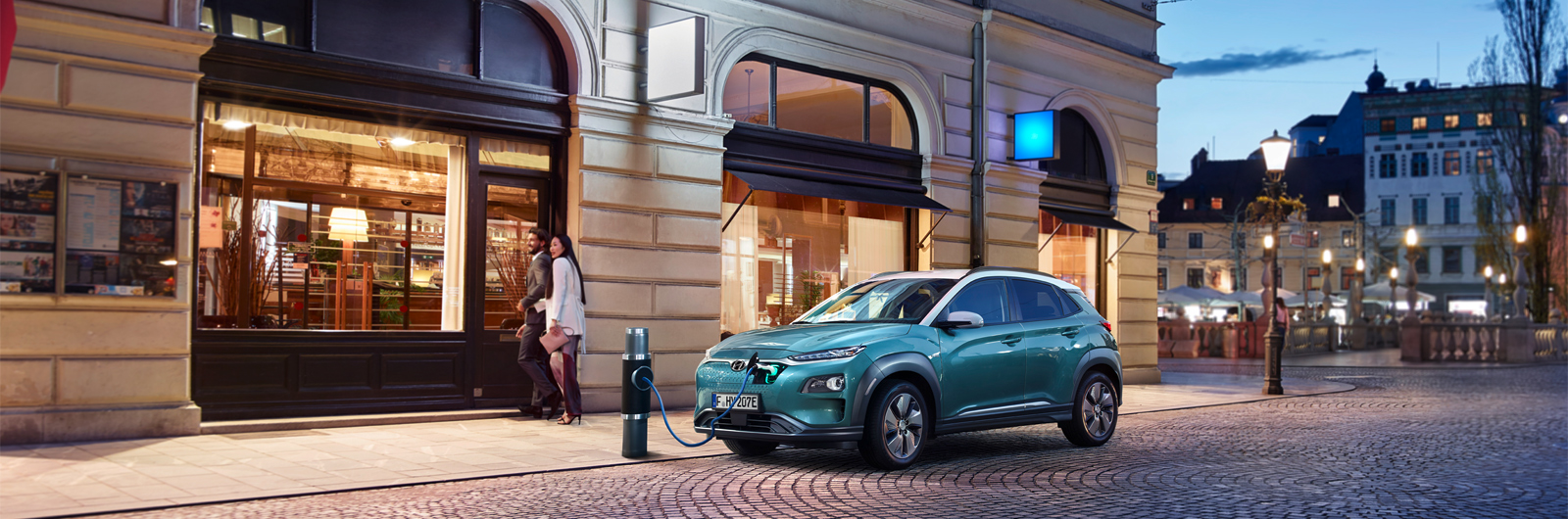 Foto vozu Kona Electric SUV, připojeného k veřejné dobíjecí stanici sítě Charge myHyundai.